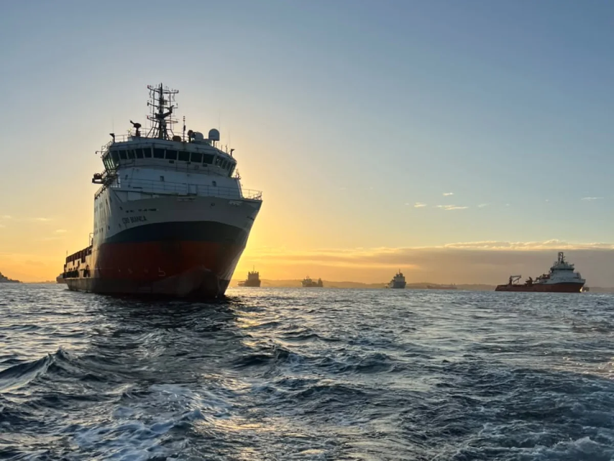Embarcação de apoio offshore fundeada, com outras embarcações ao fundo