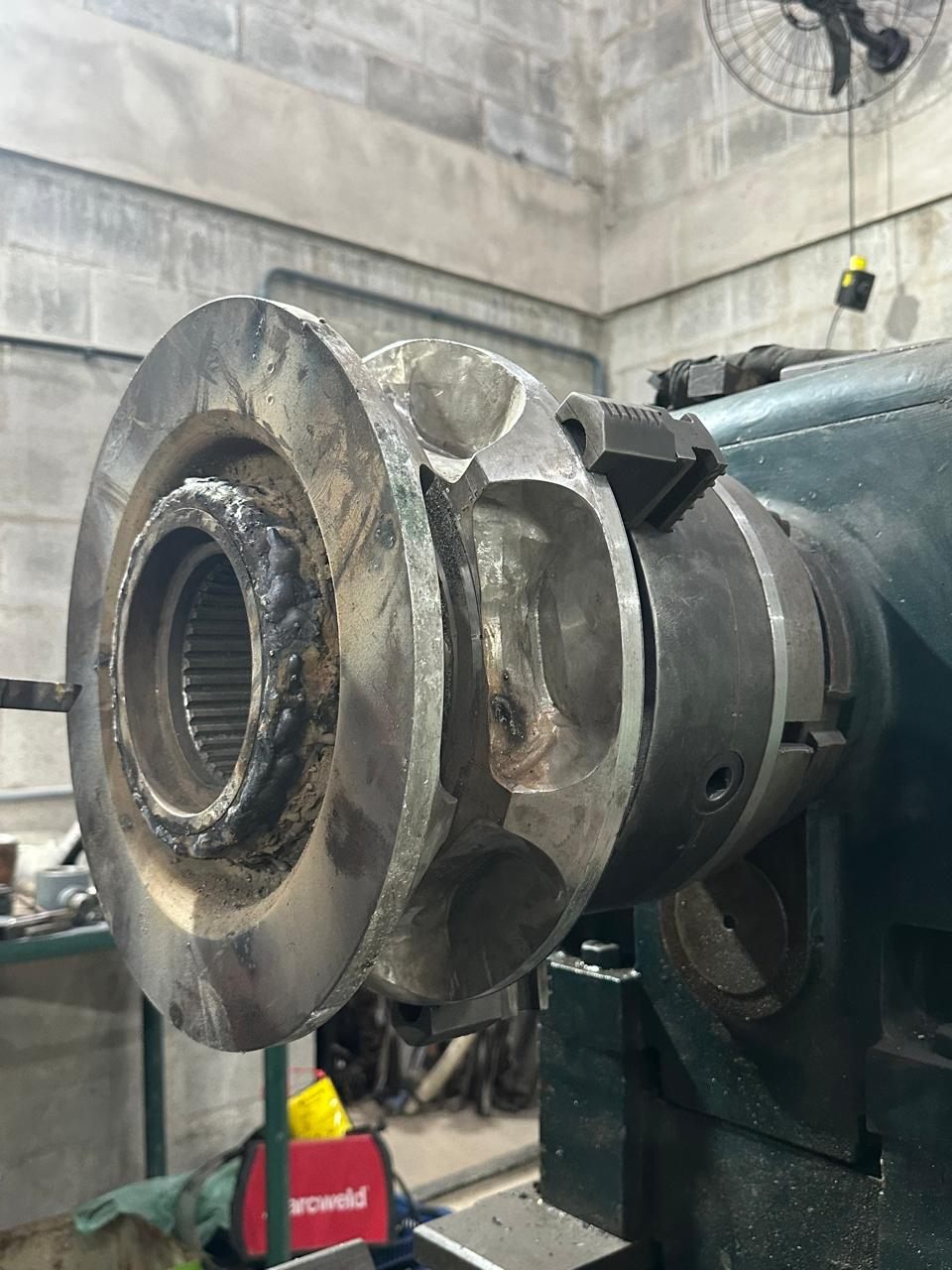 The assembly clamped in the lathe chuck, with a weld bead around the splined hub